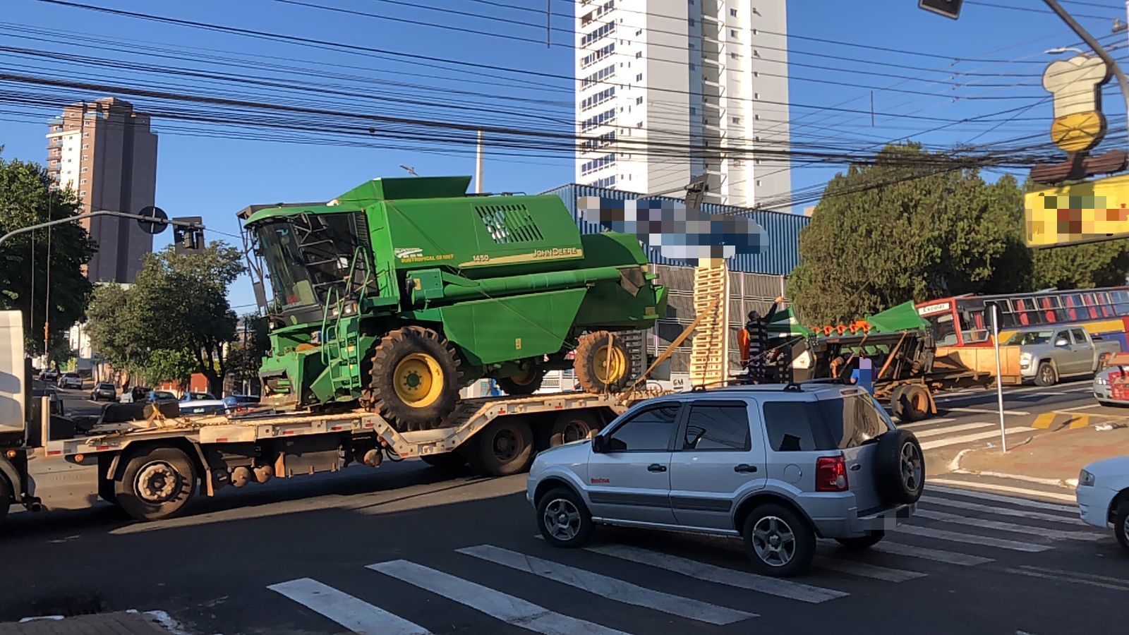 Caminhão carregado com máquina agrícola enrosca em fiação na avenida