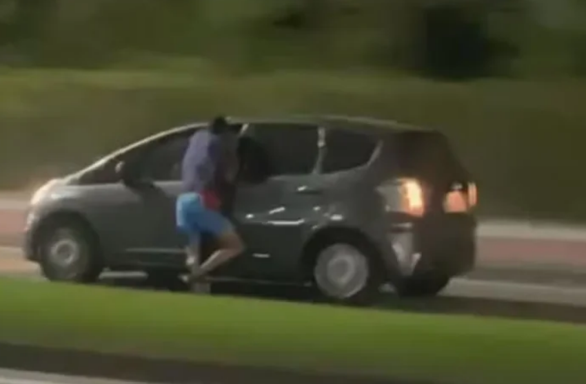  Ladrão tenta roubar celular de motorista e acaba pendurado do lado de fora de carro em movimento